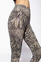 Woman wearing cream black feather printed capri leggings made from cotton lycra shown from side close up - funky simplicity