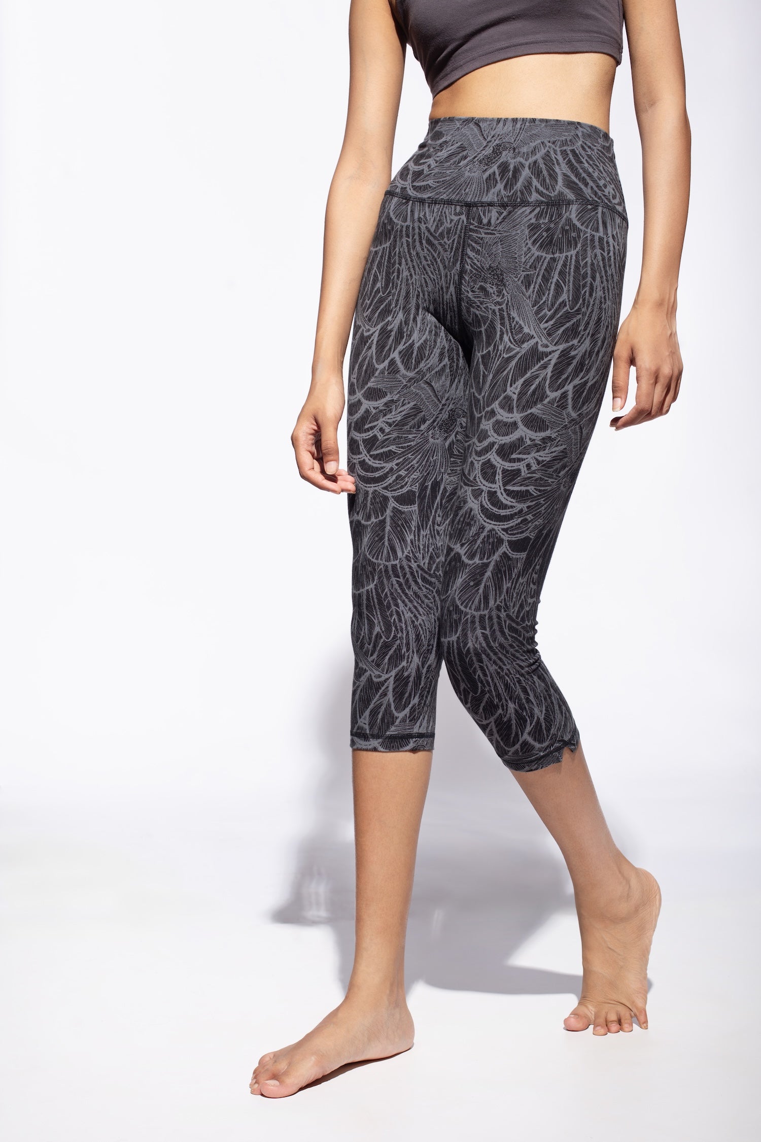 Woman wearing grey black feather printed capri leggings made from cotton lycra shown from the side front - funky simplicity