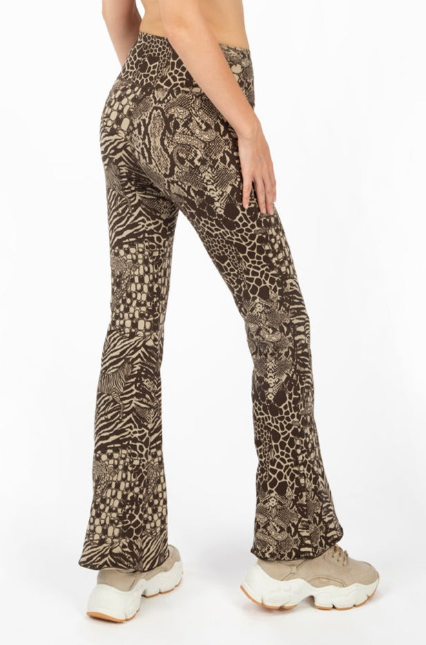 A woman wearing Funky Simplicity wild animal-print flared leggings in cream brown color shown from the back.