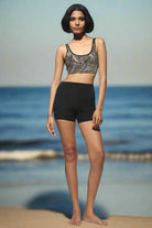 High Waist Shorts black from the front with cream black tribal cross-back bra worn on the beach with the sea on the background