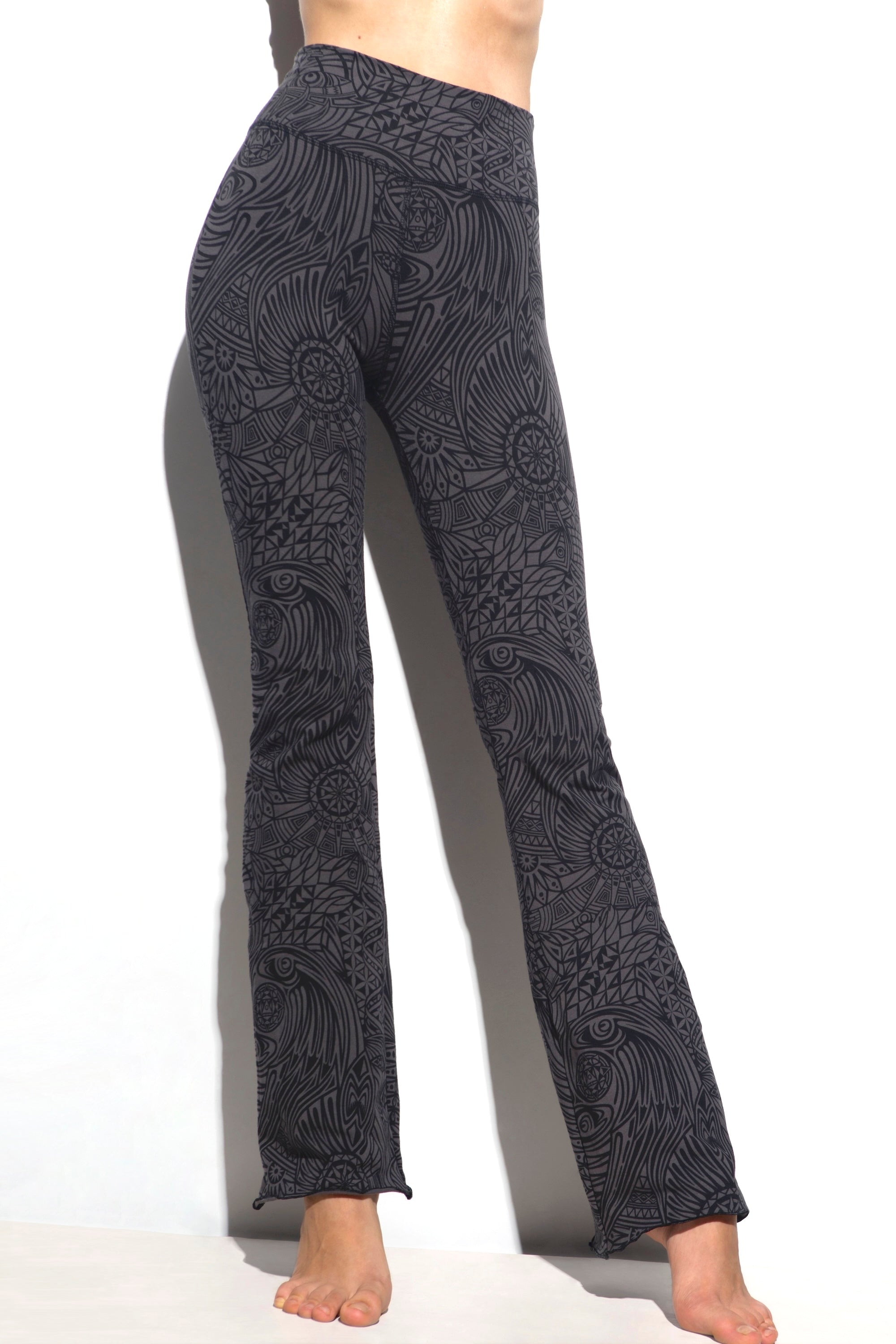 A woman wearing Funky Simplicity tribal-print flared leggings in grey black color shown from the front.