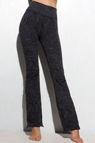 A woman wearing Funky Simplicity tribal-print flared leggings in grey black color shown from the front.